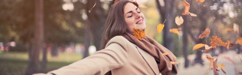 Image of a happy woman with arms stretched out enjoying the fall weather - Decoding stress