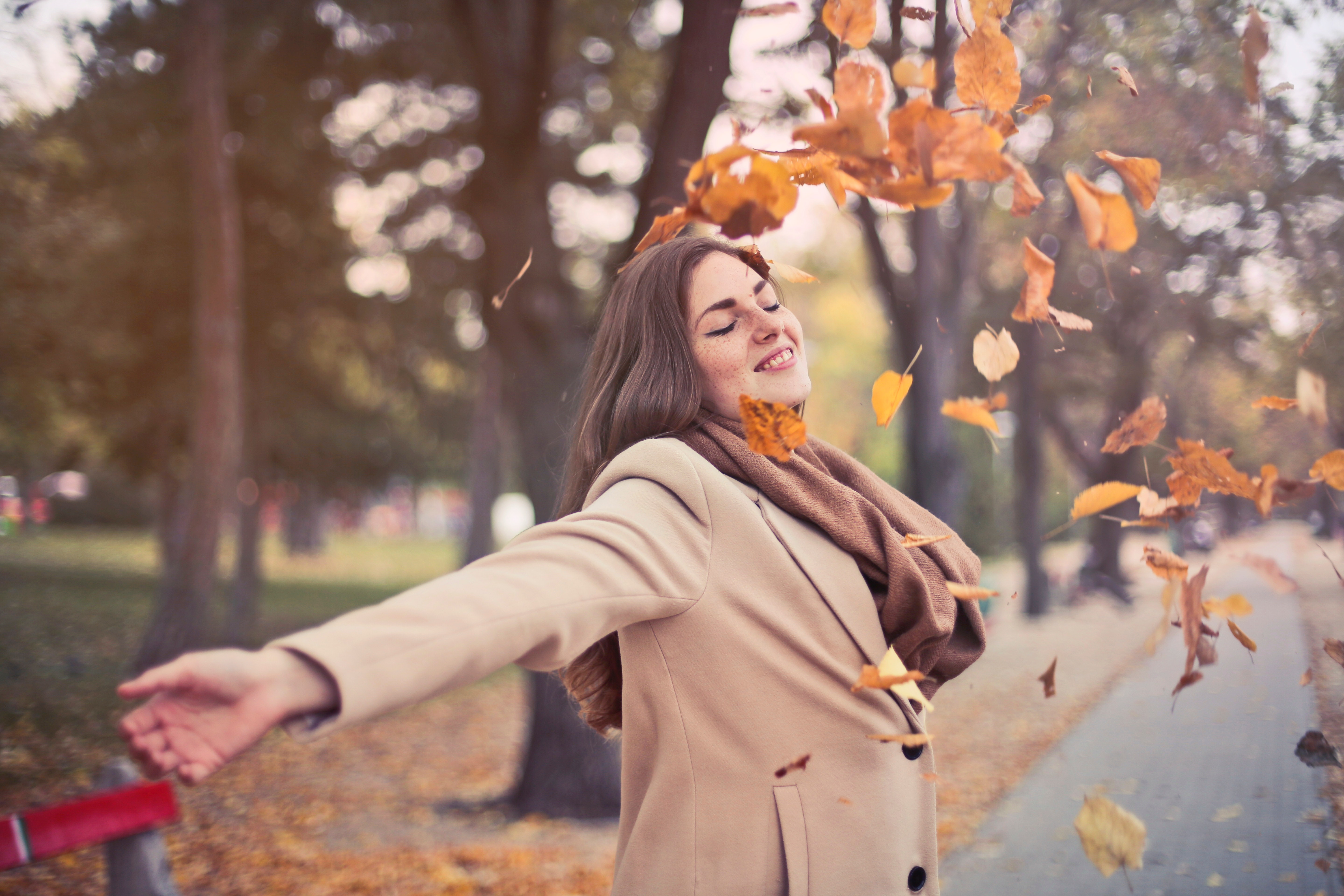 Image of a happy woman with arms stretched out enjoying the fall weather - Decoding stress